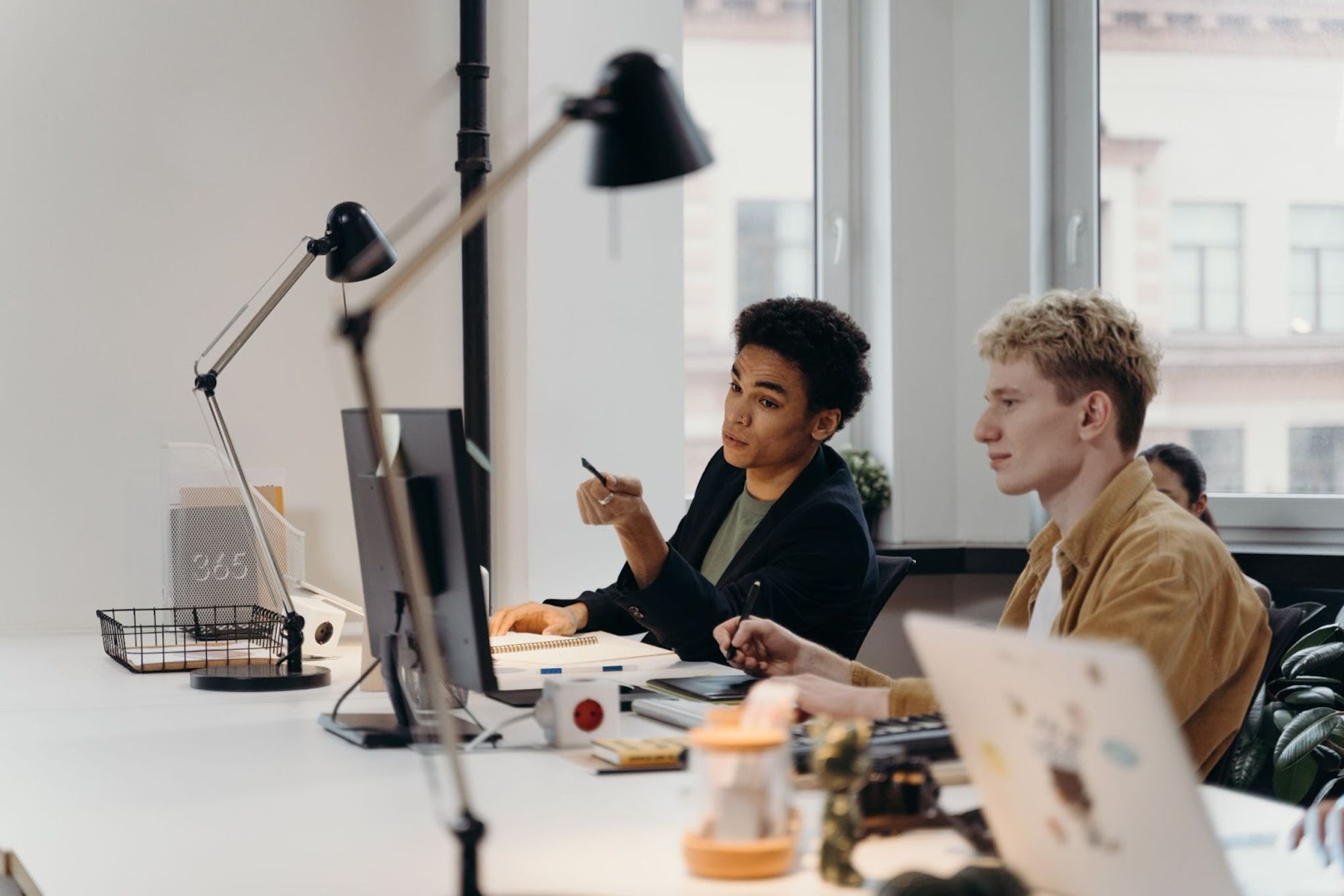 Jeunes hommes s'entraidant sur ordinateur