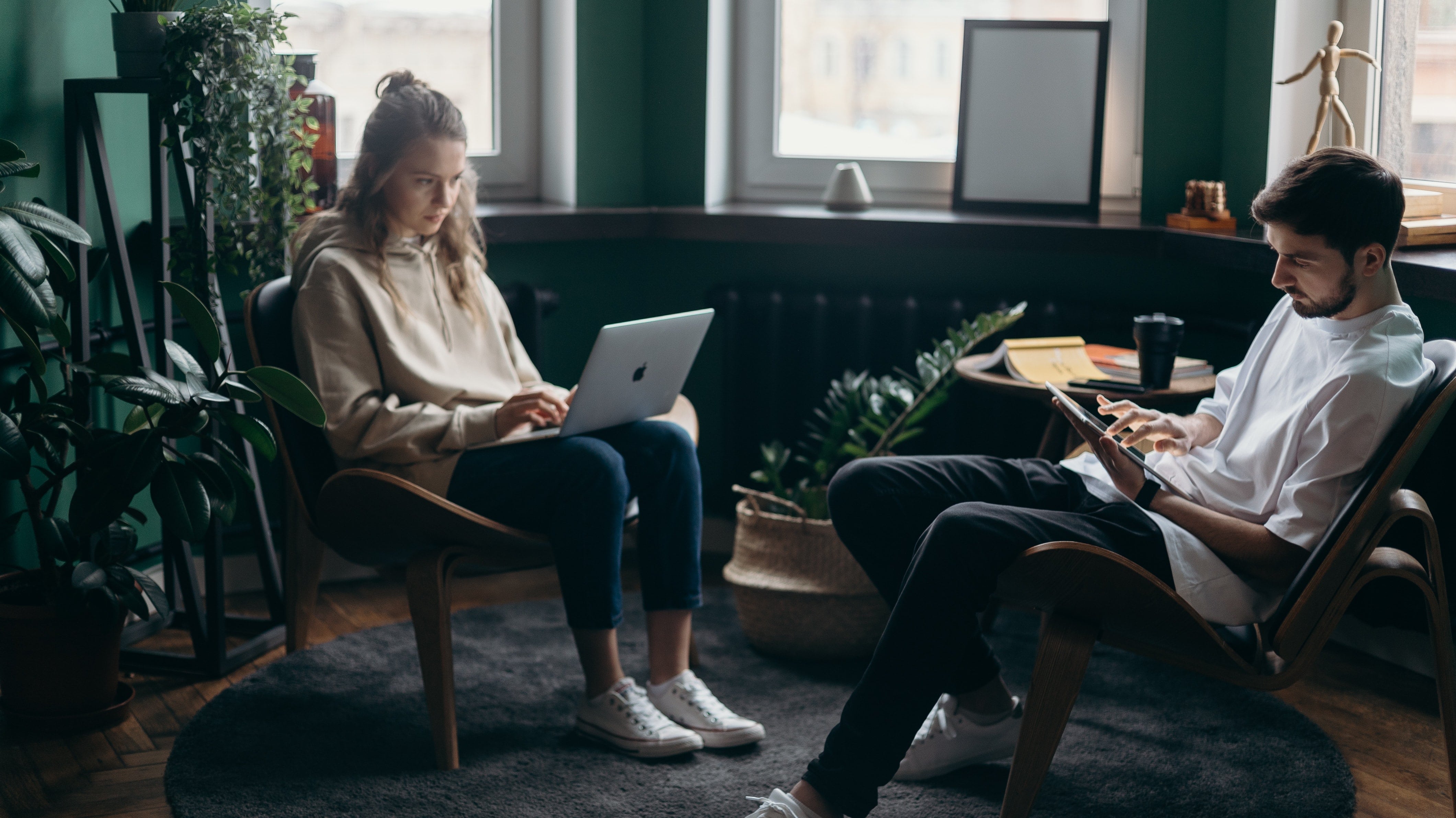 Deux jeunes travaillant sur ordinateur et tablette